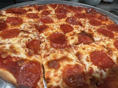 A large pepperoni pizza, cut in squares