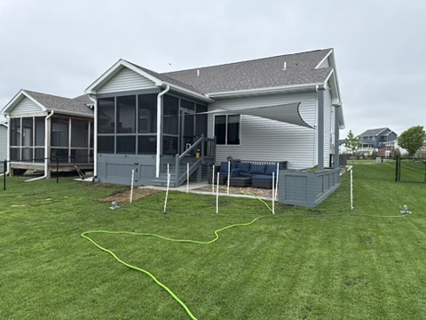 After: finished patio with seating, shade sail, and new lawn